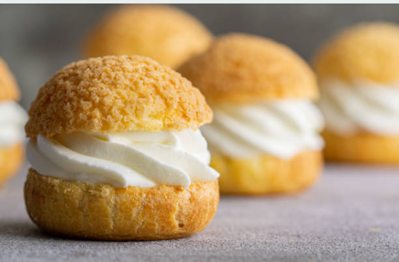 Golden pearl sugar chouquettes filled with vanilla whipped mascarpone and chocolate pastry cream, served as a traditional French snack or dessert.